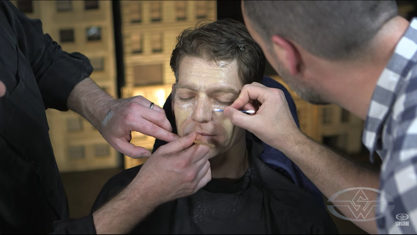 Adrian Rigby works on blending the edges while Neill Gorton works on sticking the rest of the edges on the other side of Erich’s face.