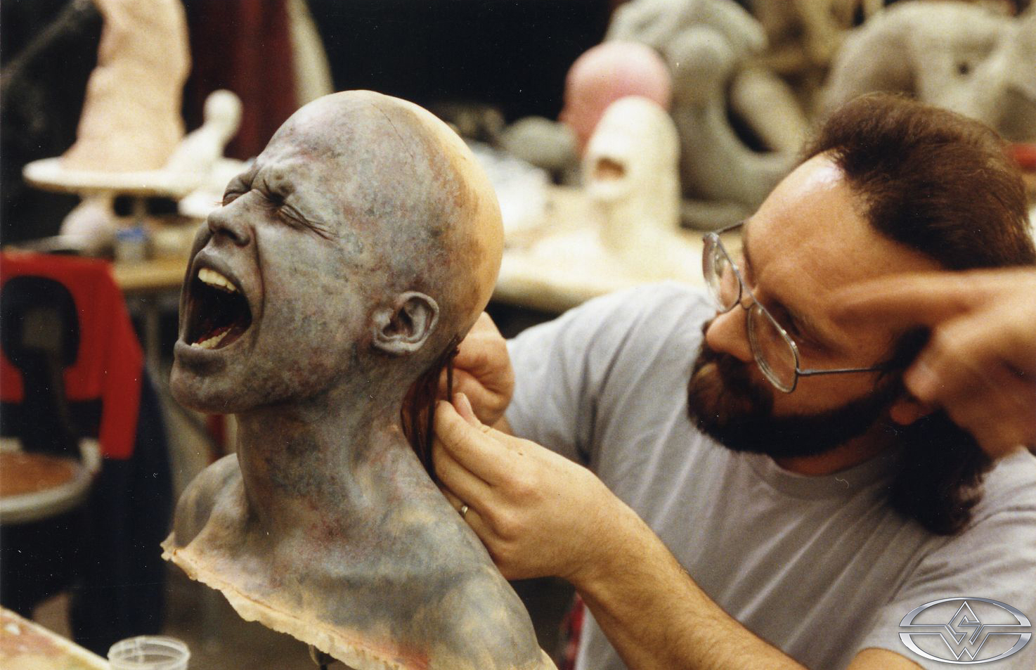 Joe Reader applies hair to a burnt Sarah puppet.