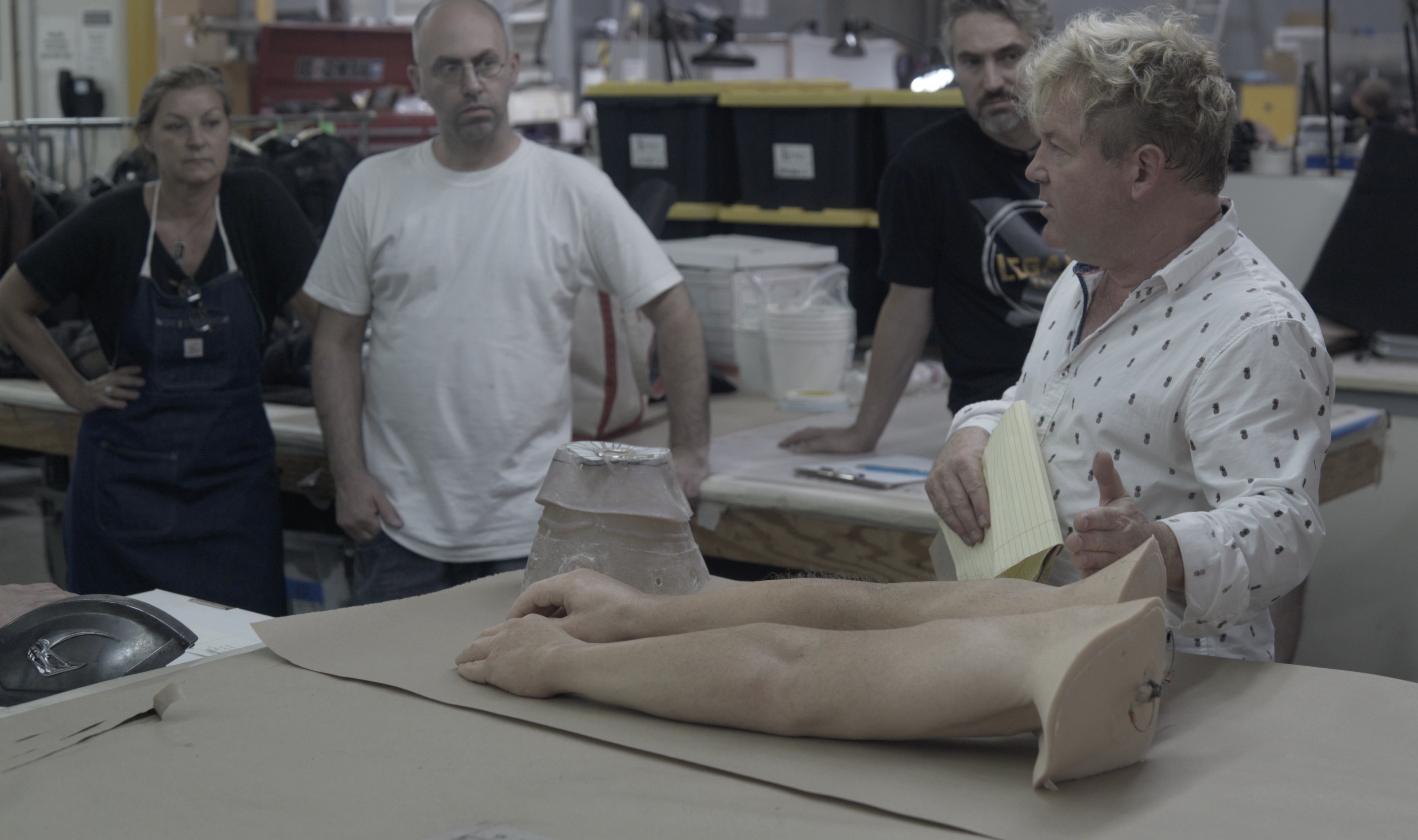 Shane Mahan discusses Nathan Fillion's T.D.K arms at Legacy Effects with [L. to R.] Connie Grayson Criswell, Jonathan Faber and David Monzingo. Image courtesy Legacy Effects/Warner Bros.