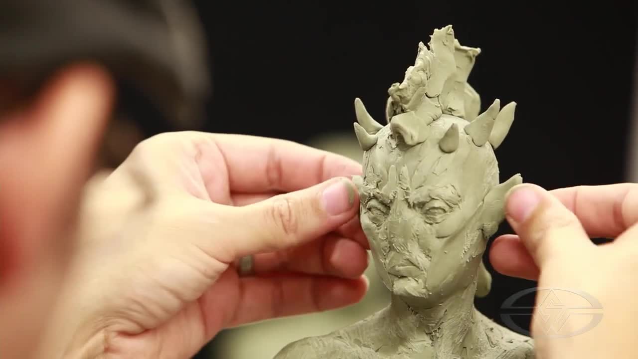 Alfred Paredes considers ear placement on his sculpture.