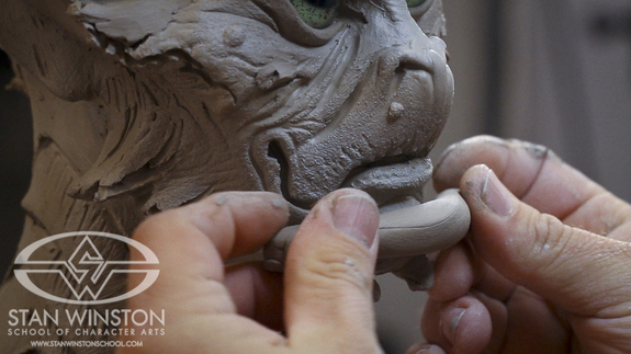 Don applies a generous clay “worm” to the chin and lower lip of his new alien soldier, creating a massive jaw that instantly informs the character and communicates heroic strength and leadership.
