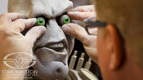 Don test fits a pair of glass eyes into his deeply set sockets allowing the character to come momentarily to life.