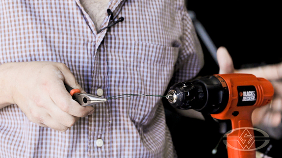 Shannon Shea demonstrates how a machine makes spinning wire faster.