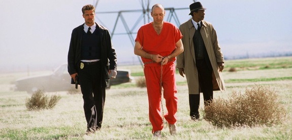 A pivotal scene in the film, featuring Brad Pitt as David Mills, Morgan Freeman as Detective Lt. William Somerset, and Kevin Spacey as John Doe.