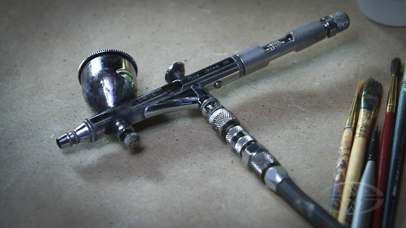 And pick up one of these... An Iwata airbrush is his weapon of choice.