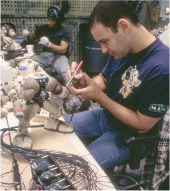 Jim Charmatz paints his animatronic character, Slam-Fist, as Charles Ratteray assists.