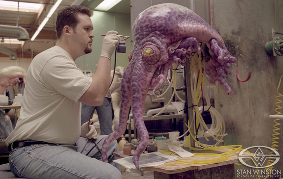 Trevor Hensley adds paint details to the animatronic, tentacled Thermian puppet.